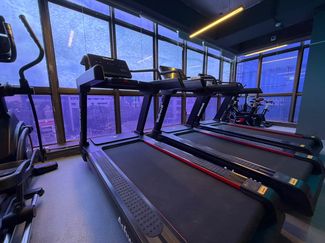 Treadmills and spin bikes by the windows